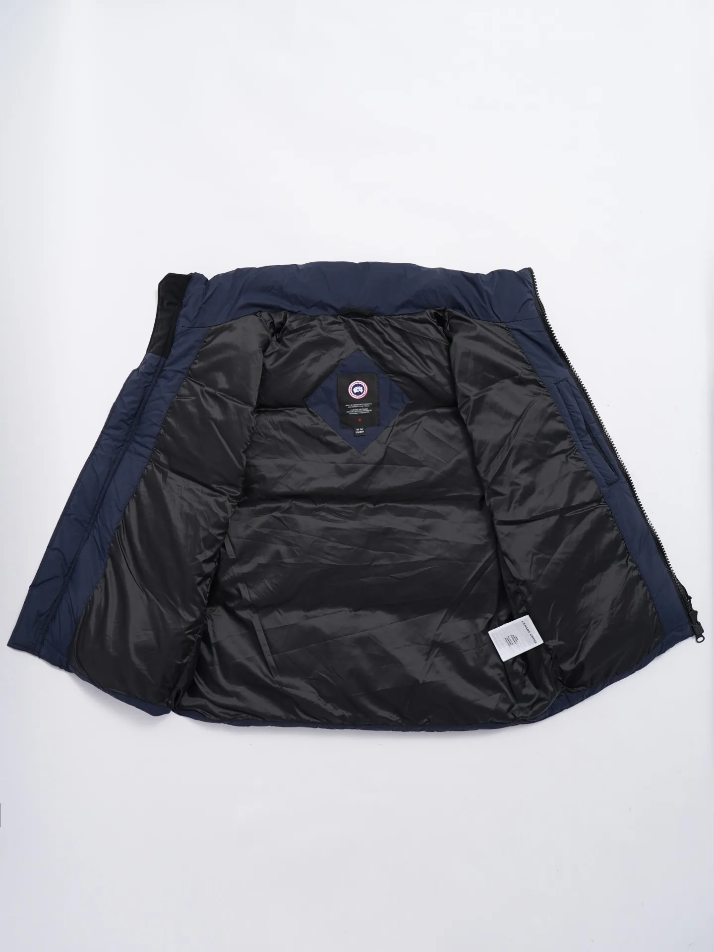 P580 Canada gooes Lawrence Down Vest (high version) With a durable shell and quilted body, the Lawrence Down Vest is a must-have for all seasons. The fabric has a durable soft touch. Longer hem at back for added protection. Reflective double-stripe grip tape at back. The Lawrence features an engineered down-filled collar to block strong winds, a two-way front zip and a longer rear hem. Color: black with red label, black with black label, desert color, ocean blue Size: XS -2XL